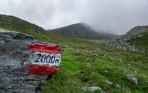 red and white "2000m" milestone on a foggy mountain