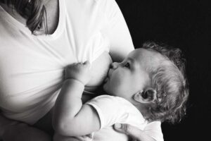 Black and white photo of a child being breastfed